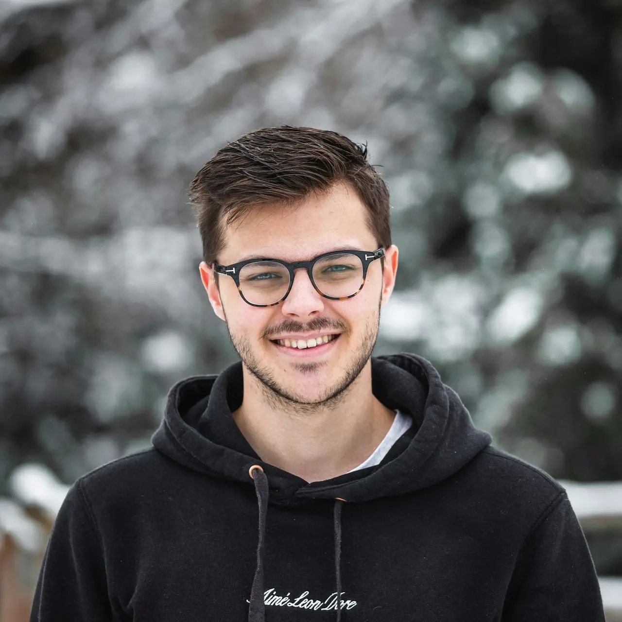 man in black hoodie wearing black framed eyeglasses